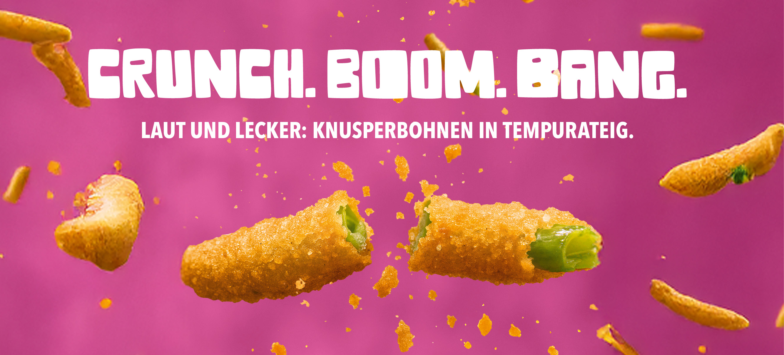 Knusperbohnen in goldener Tempurateig auf pinkem Hintergrund. Große, weiße Headline: ‚Crunch. Boom. Bang.‘ Darunter der Text: ‚Laut und lecker: Knusperbohnen in Tempurateig.‘ Im Fokus: kross gebackene grüne Bohnen, umgeben von knusprigen Bröseln. Perfekt als Snack und Fingerfood.